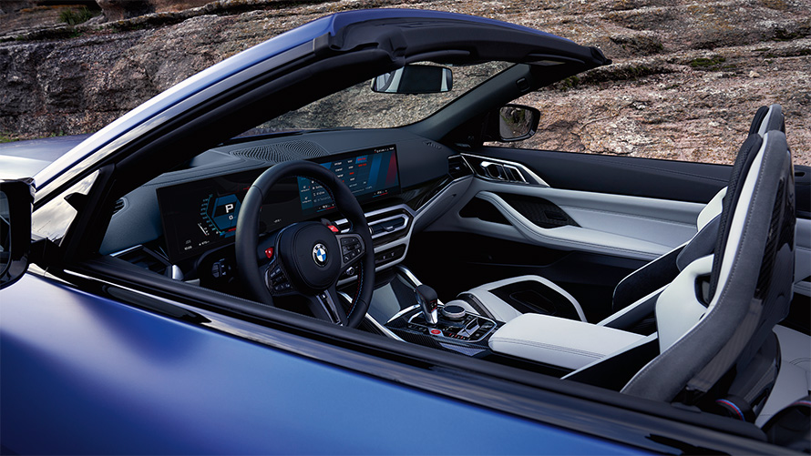 BMW M4 Competition kabrioletas su M xDrive (G83) 2021, interjeras su atviru stogu BMW M4 Competition kabrioletas su M xDrive (G83) 2021, mėlynos BMW Individual Frozen Portimao Blue metalizuotos kėbulo spalvos, vairuotojo erdvė ir interjeras su atviru stogu