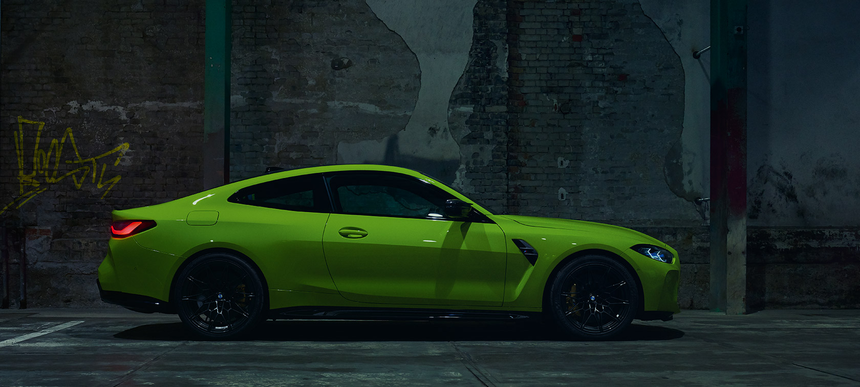 BMW M4 CSL G82 trijų ketvirčių vaizdas iš galo BMW M4 CSL G82 BMW Individual pilkos <i>Frozen Brooklyn Grey</i> metalizuotos spalvos lenktynių trasoje važiuojančio automobilio trijų ketvirčių vaizdas iš galo