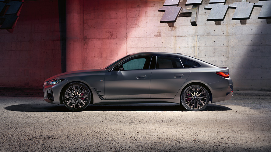BMW M440i xDrive Gran kupė (G26) 2021 vaizdas iš šono BMW M440i xDrive Gran kupė (G26) 2021, pilkos Frozen Pure Grey metalizuotos kėbulo spalvos, vaizdas iš priekio sienos fone