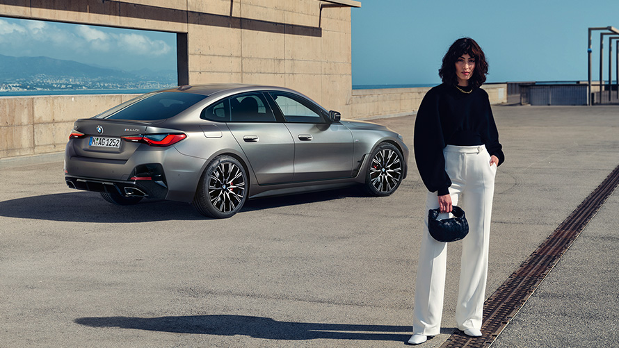 BMW M440i xDrive Gran kupė (G26) 2021, trijų ketvirčių vaizdas iš galo su modeliu BMW M440i xDrive Gran kupė (G26) 2021, pilkos Frozen Pure Grey metalizuotos kėbulo spalvos, trijų ketvirčių vaizdas iš galo su modeliu