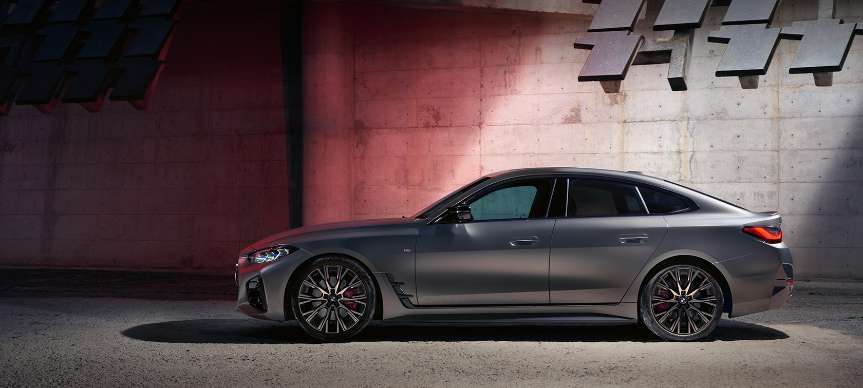 BMW M440i xDrive Gran kupė (G26) 2021 vaizdas iš šono sienos fone BMW M440i xDrive Gran kupė (G26) 2021, BMW Individual pilkos Frozen Pure Grey metalizuotos kėbulo spalvos, vaizdas iš šono sienos fone