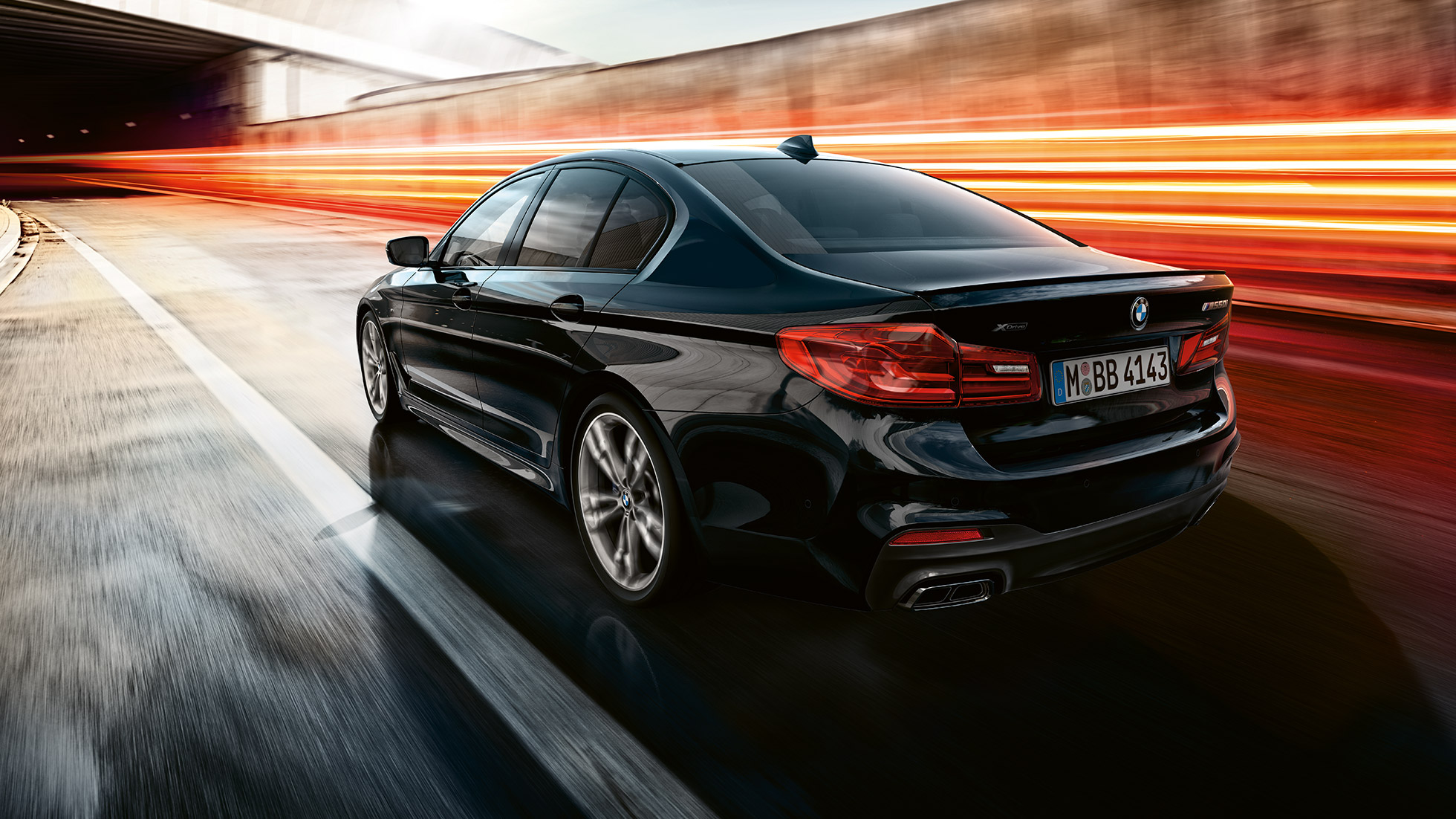 Vairavimo dinamika Keliu važiuojančių BMW M550i ir BMW M550d trijų ketvirčių vaizdas iš galo.