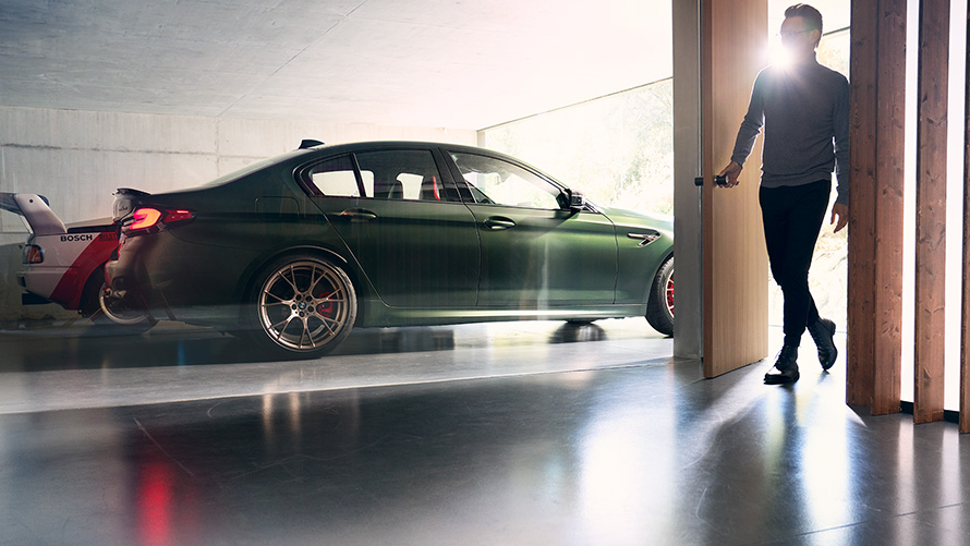 BMW M5 CS F90 2021 žalio „Frozen Deep Green“ metaliko spalvos vaizdas iš šono garaže