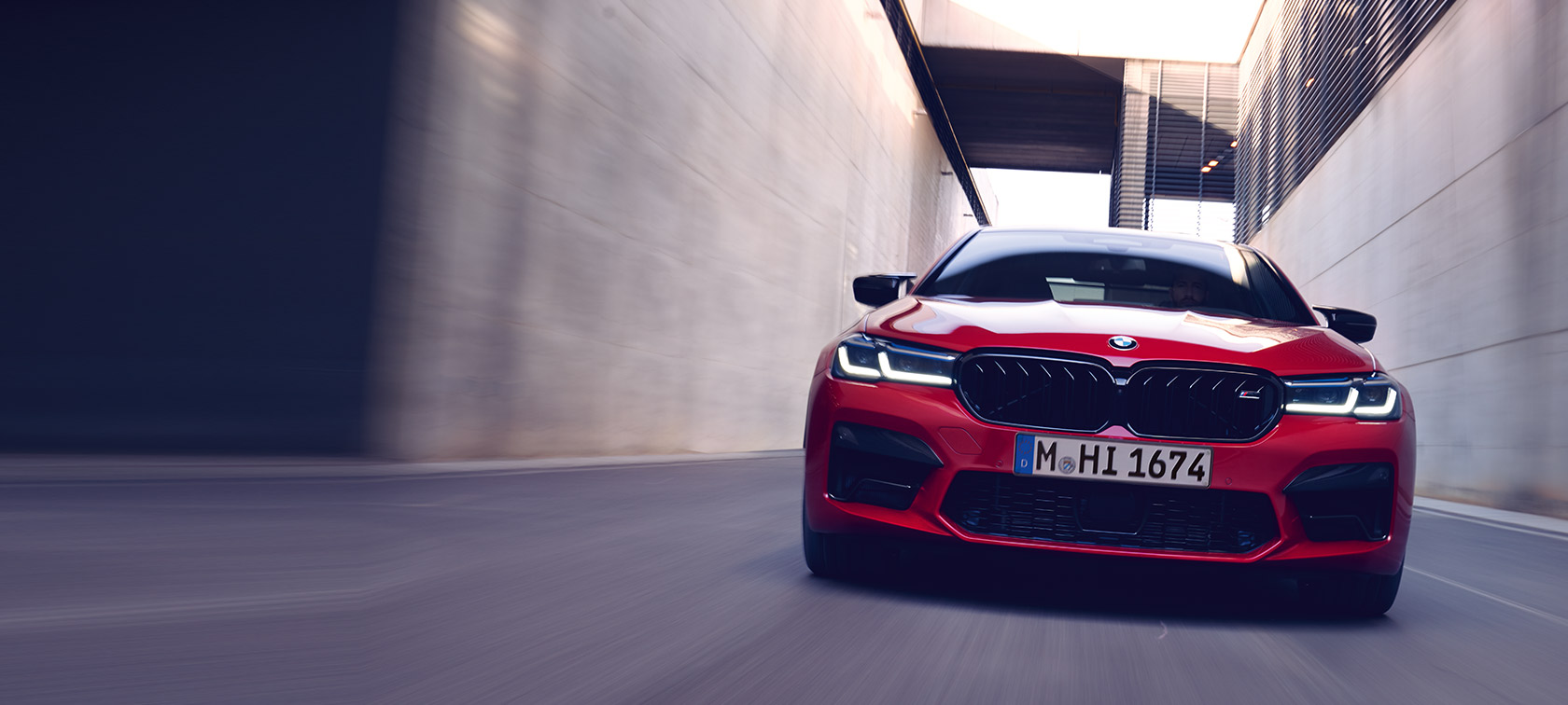 BMW M5 Competition F90 LCI Facelift 2020 BMW Individual raudonos Imola Red spalvos važiuojančio automobilio vaizdas iš priekio