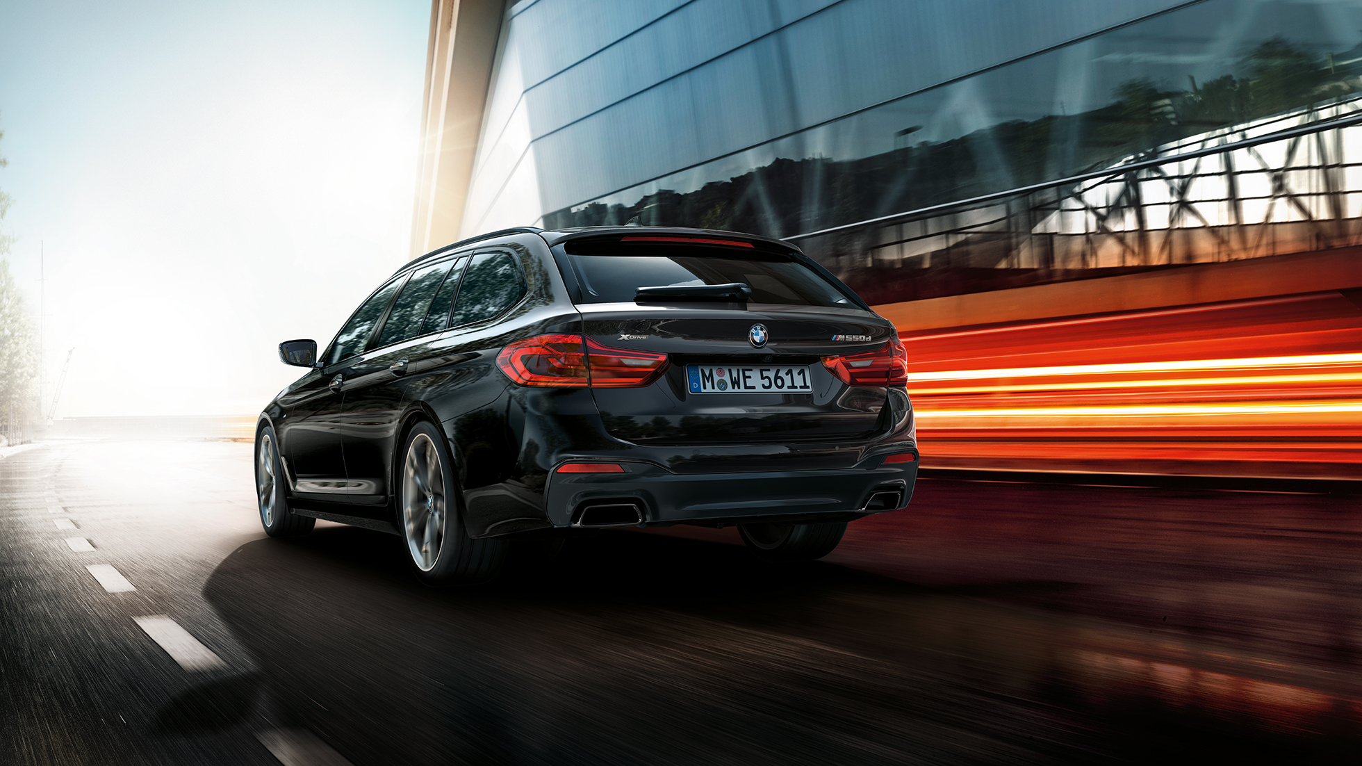Eksterjero dizainas BMW M550d xDrive Touring Eksterjero dizainas BMW M550d xDrive Touring G31 Azurite Black juodo metaliko spalvos trijų ketvirčių vaizdas iš galo BMW M550d Touring akcentai
