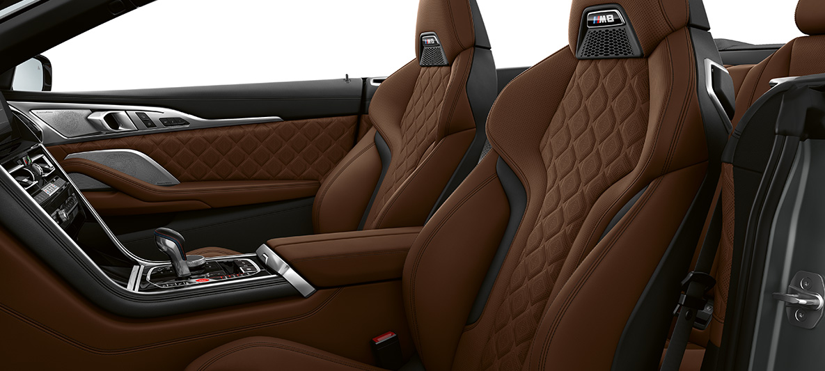 M sportinės sėdynės su M ženkleliu. BMW M8 kabrioletas, interjeras su M sportinėmis Merino Taruma Brown rudos odos sėdynėmis.