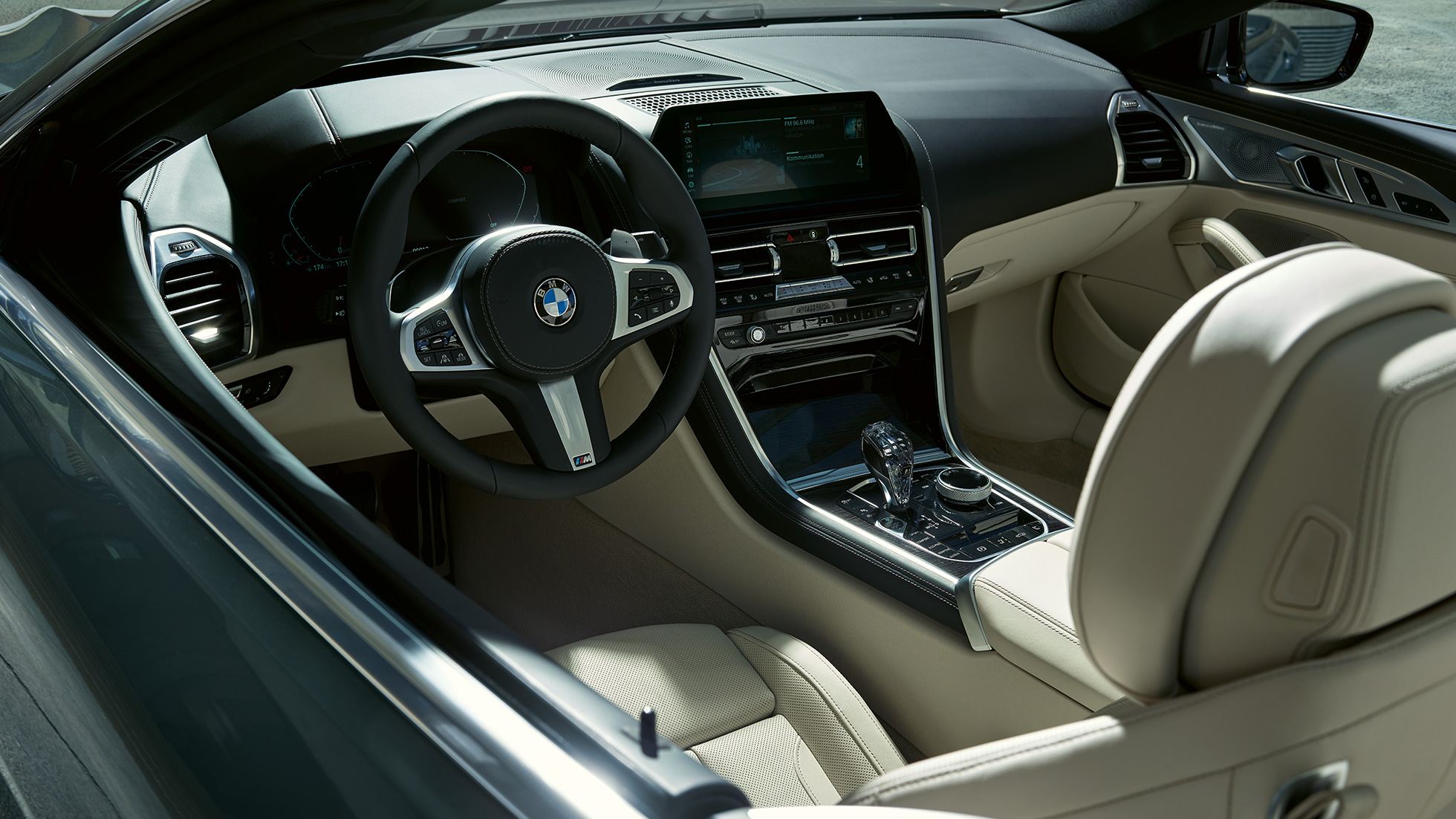 BMW M850i xDrive kabrioletas, vairuotojo erdvė. BMW M850i xDrive kabrioletas Dravit Grey pilko metaliko spalvos su atviru minkštu stogu, vairuotojo erdvė su M odiniu vairu.
