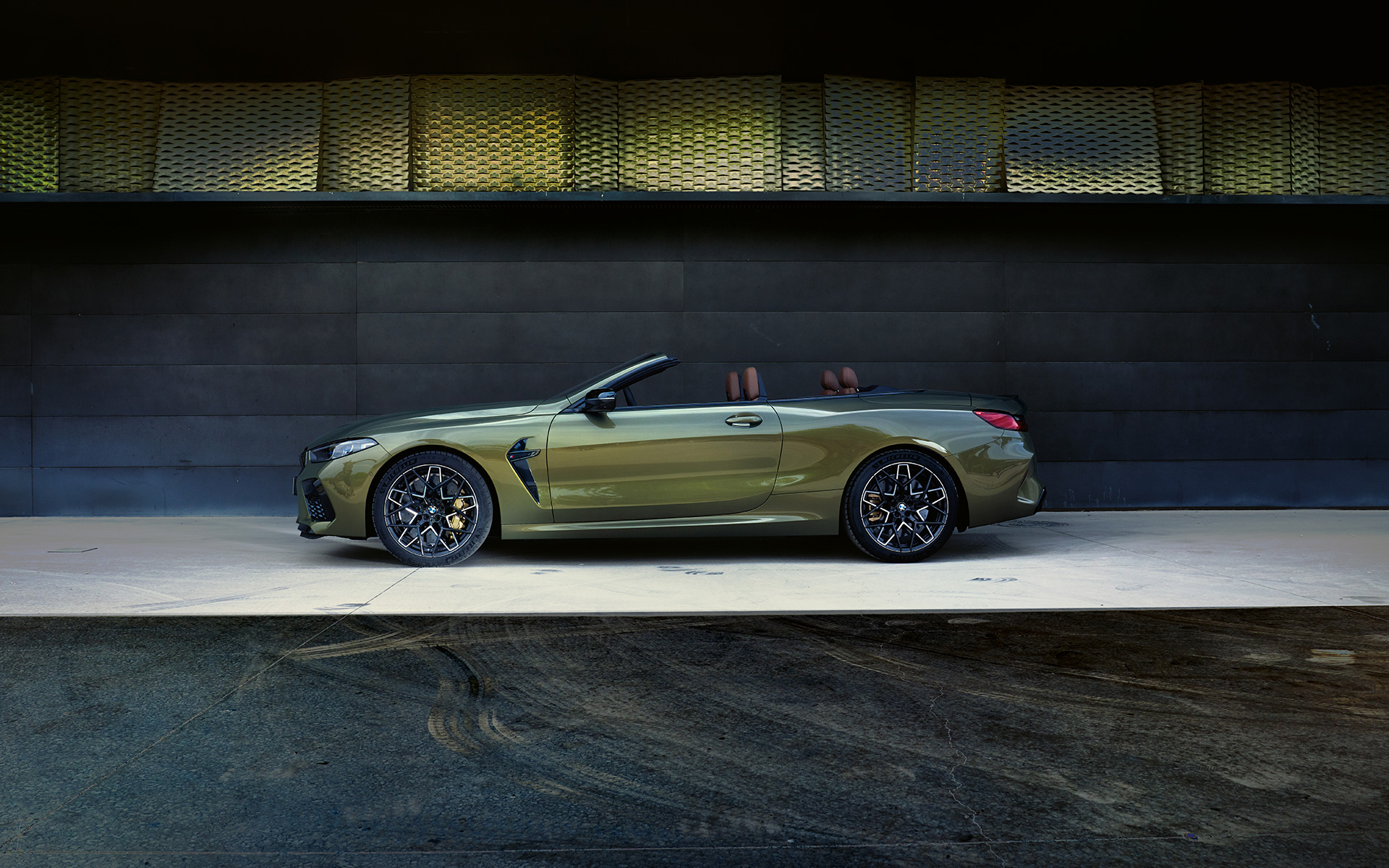 Vaizdas iš šono ant pakylos BMW M8 Competition kabrioletas F91 LCI Facelift 2022 BMW M8 Competition kabrioletas F91 LCI Facelift 2022 BMW Individual Brass metalizuotos kėbulo spalvos vaizdas iš šono ant pakylos