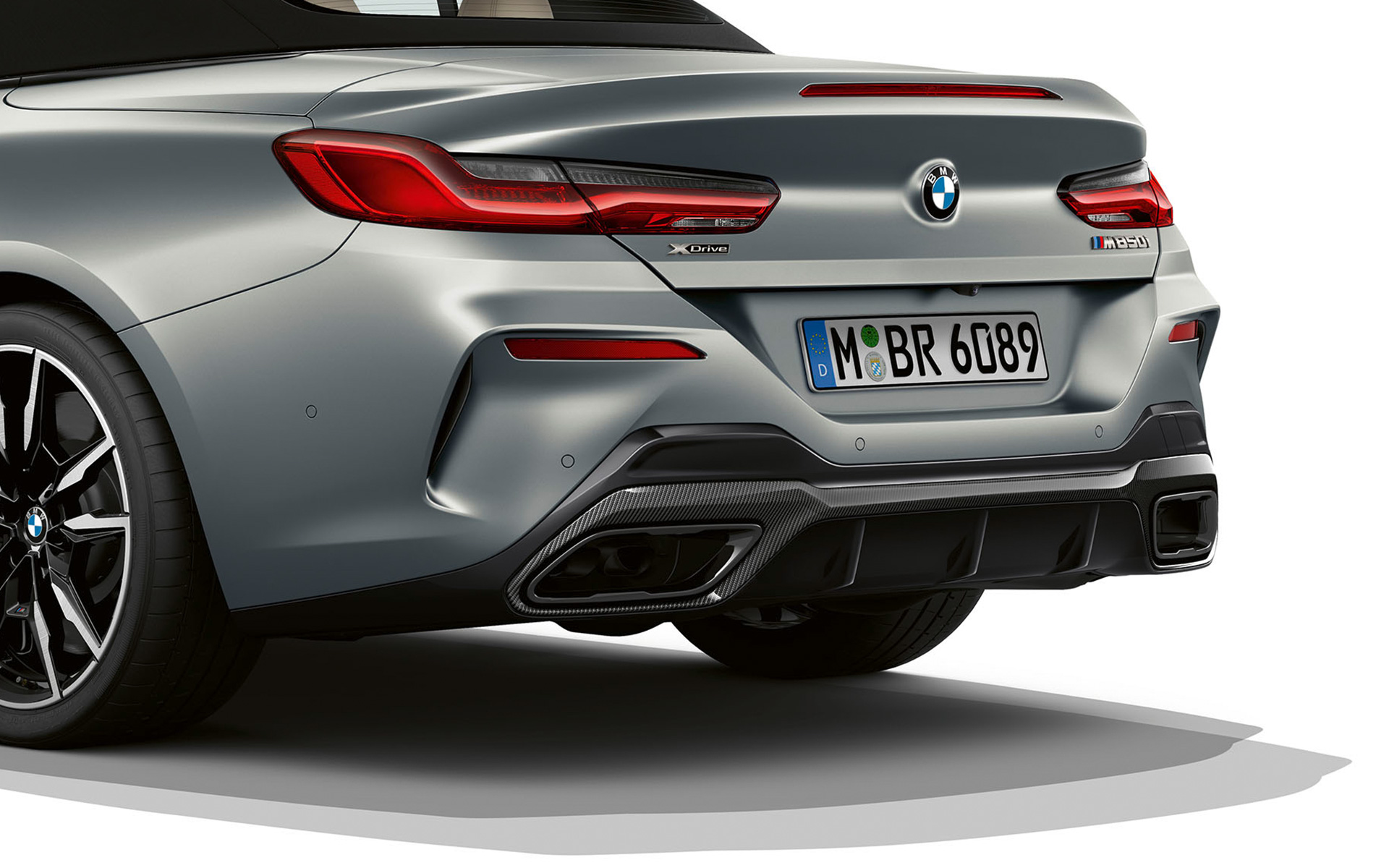 Trijų ketvirčių vaizdas iš galo galinio bamperio apdaila BMW M850i xDrive kabrioletas G14 LCI Facelift 2022 BMW M850i xDrive kabrioletas G14 LCI Facelift 2022 BMW Individual pilkos Frozen Pure Grey metalizuotos spalvos galinio bamperio apdailos trijų ketvirčių vaizdas iš arti