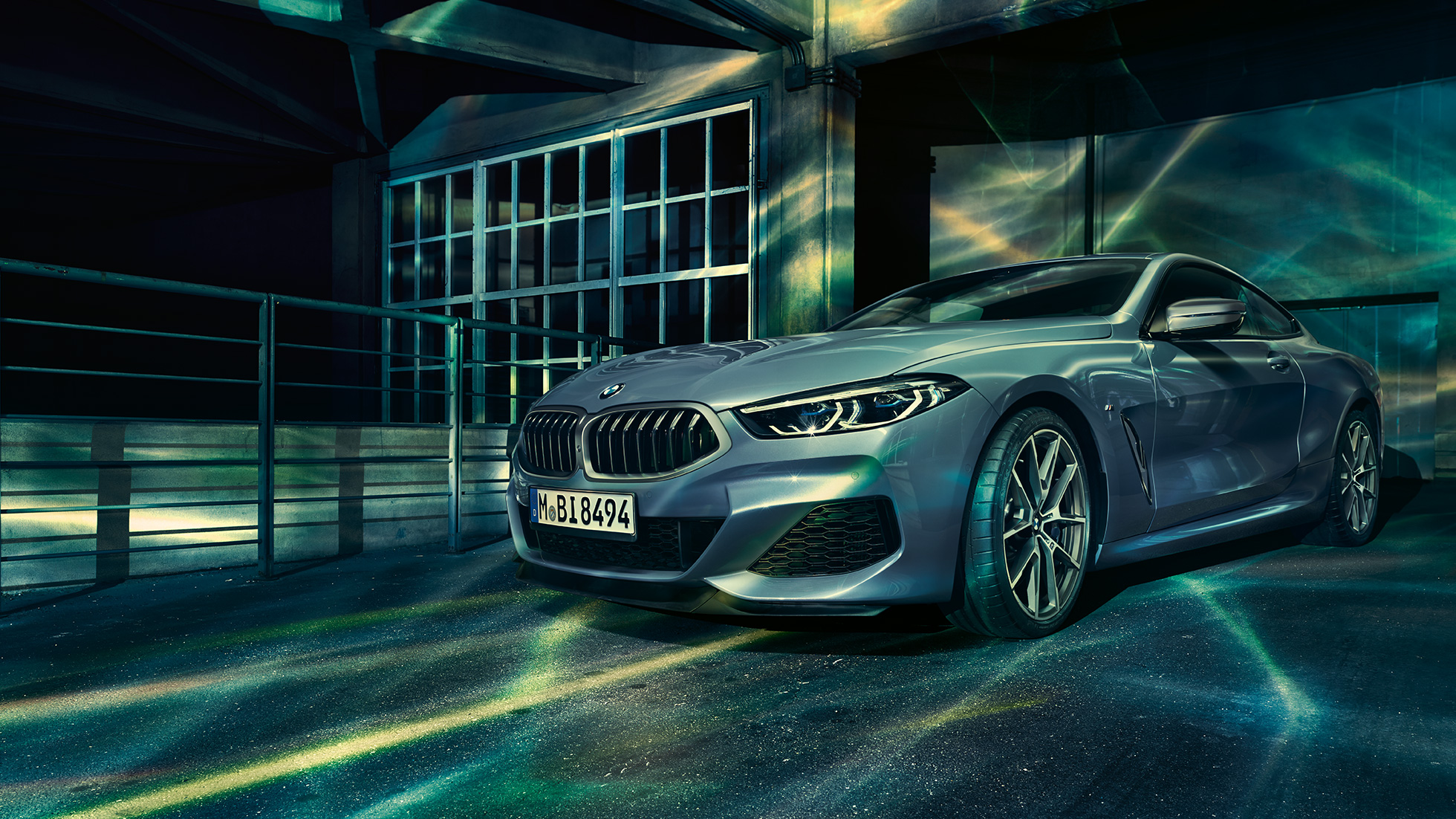 BMW M850i xDrive kupė,trijų ketvirčių vaizdas iš priekio BMW M850i xDrive kupė Barcelona Blue mėlyno metaliko spalvos, trijų ketvirčių priešais pastatą stovinčio automobilio vaizdas iš priekio