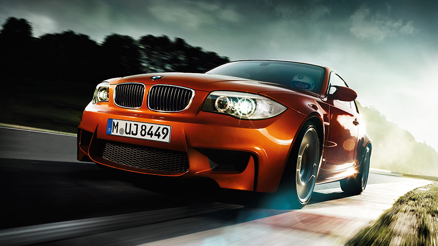 Gatve važiuojančio BMW 1 serijos M kupė (E82) trijų ketvirčių vaizdas iš priekio BMW M serija, gatve važiuojančio BMW 1 serijos M kupė (E82) trijų ketvirčių vaizdas iš priekio