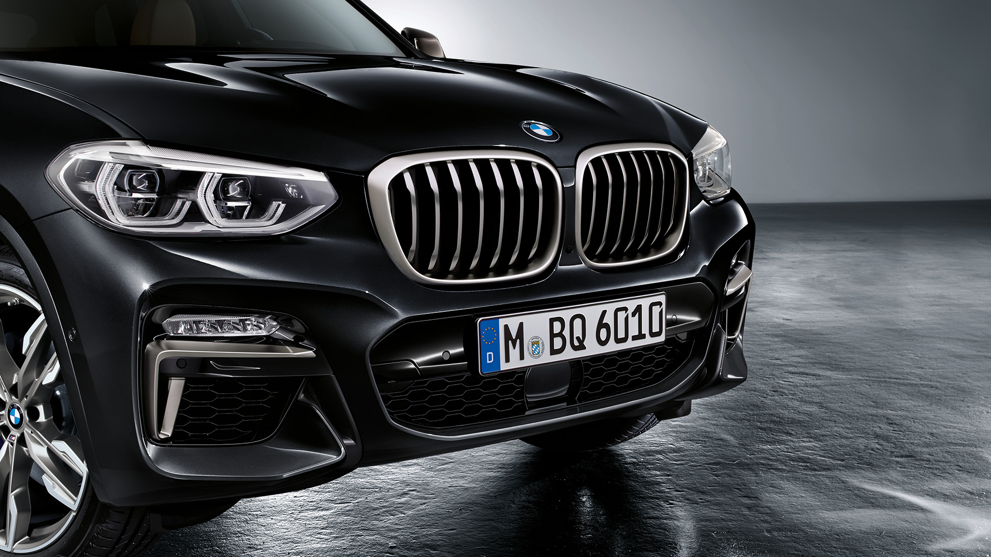 BMW X3 M40i ir BMW X3 M40d, priekinė dalis. BMW X3 M40i ir BMW X3 M40d „Black Sapphire“ juodo metaliko spalvos, eksterjeras, priekinė dalis su „Cerium Grey“ pilkos spalvos dizaino elementais.