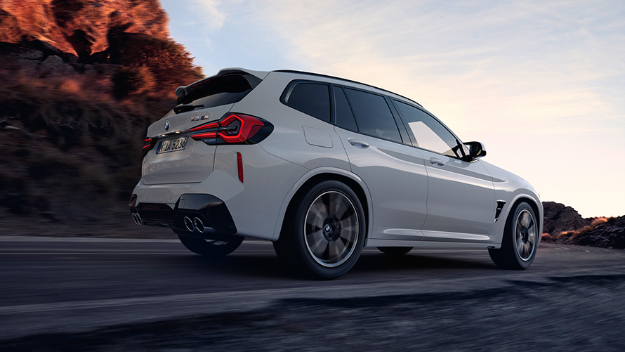 BMW X3 M (F97) LCI Facelift 2021 vaizdas iš šono žemu kampu BMW X3 M (F97) LCI Facelift 2021 baltos Alpine White kėbulo spalvos, vaizdas iš šono žemu kampu