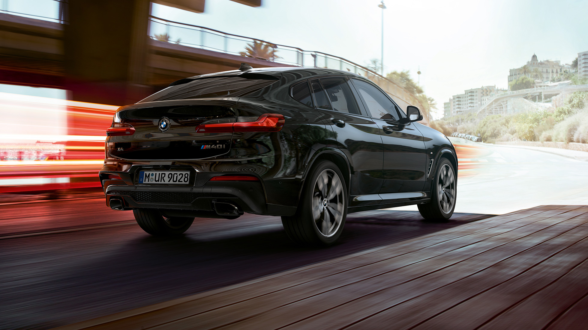BMW X4 M40i, trijų ketvirčių vaizdas iš galo. BMW X4 M40i „Black Sapphire“ juodo metaliko spalvos, eksterjeras, trijų ketvirčių vaizdas iš galo, apšviesta dešinė pusė.