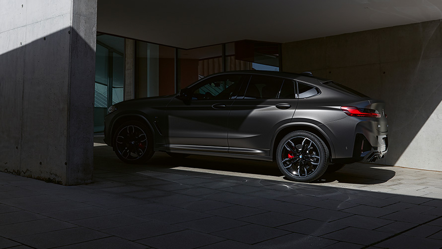 BMW X4 M40i (G02) LCI 2021 Facelift, pusiau apšviesto automobilio vaizdas iš šono prie namų įėjimo