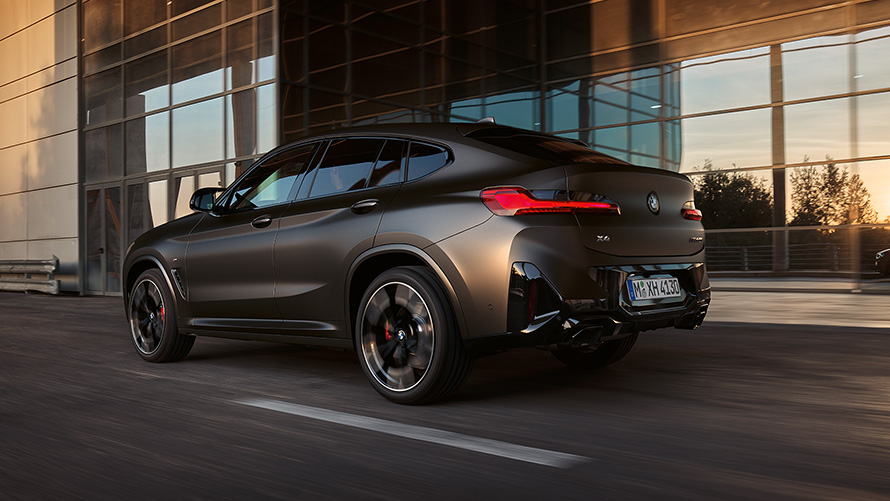 BMW X4 M40i (G02) LCI 2021 Facelift trijų ketvirčių vaizdas iš galo stiklinio fasado fone