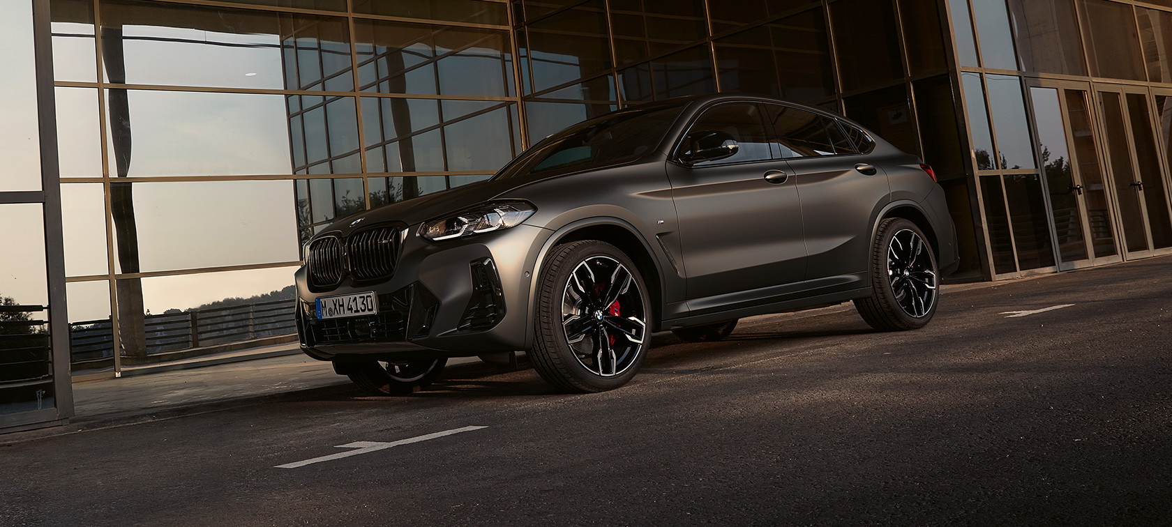BMW X4 M40i (G02) LCI 2021 Facelift trijų ketvirčių vaizdas iš priekio BMW X4 M40i (G02) LCI 2021 Facelift trijų ketvirčių vaizdas iš priekio stiklinio fasado fone