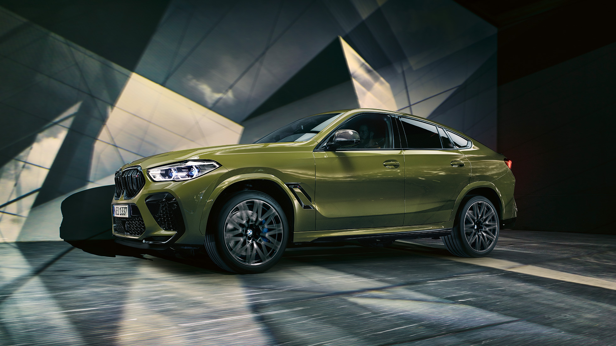 BMW X6 M Competition,vaizdas iš šono BMW X6 M Competition su M lengvo lydinio ratlankiais F96, su BMW Individual specialia Urban Green dažų apdaila, vaizdas iš šono