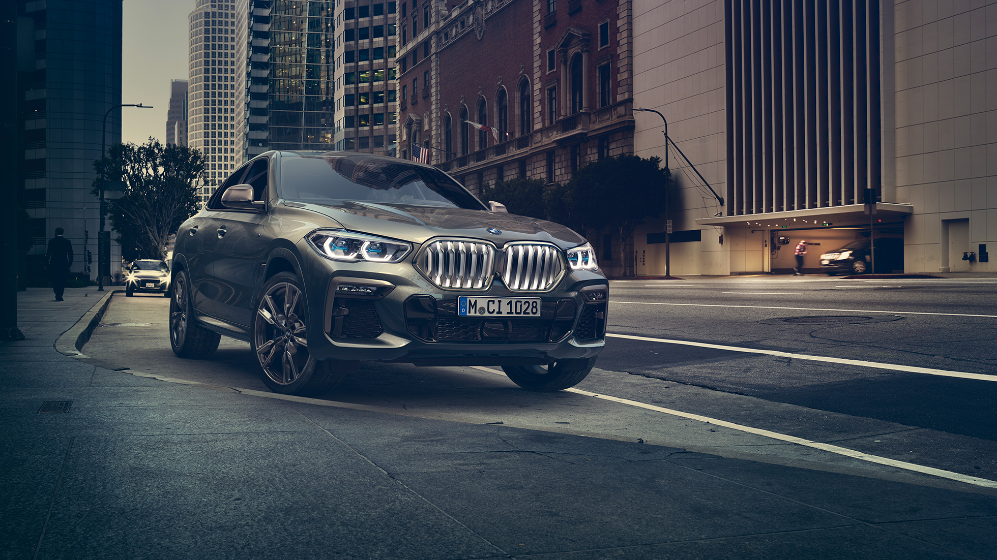 Stovintis BMW X6 M50i BMW X6 M50i stovinčio miesto fone trijų ketvirčių vaizdas iš priekio