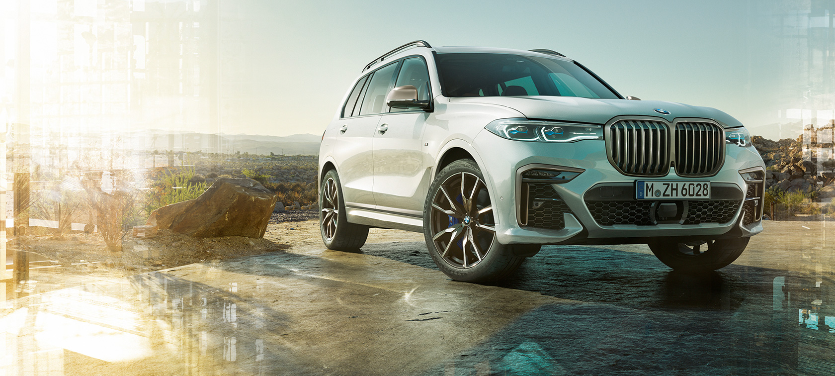 BMW X7 M automobilis, trijų ketvirčių priekinis vaizdas iš kairės BMW X7 M Mineral White baltos spalvos, G07, stovinčio automobilio trijų ketvirčių priekinis vaizdas iš kairės
