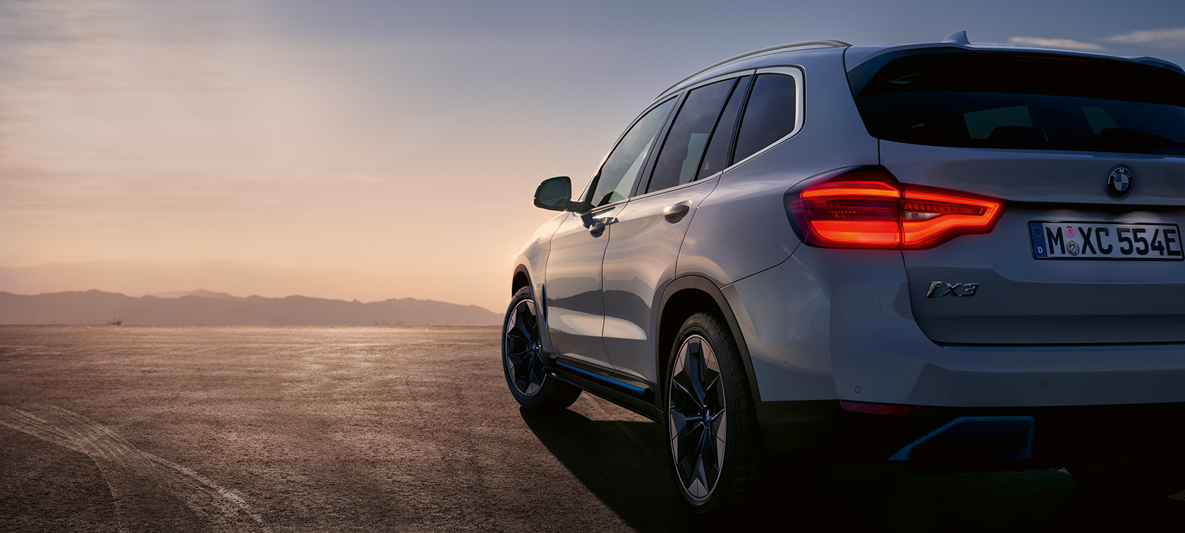 Gatvėje stovintis BMW iX3 G08 BMW iX3 G08 2020 balto Mineral White metaliko spalvos, gatvėje stovinčio automobilio trijų ketvirčių vaizdas iš galo