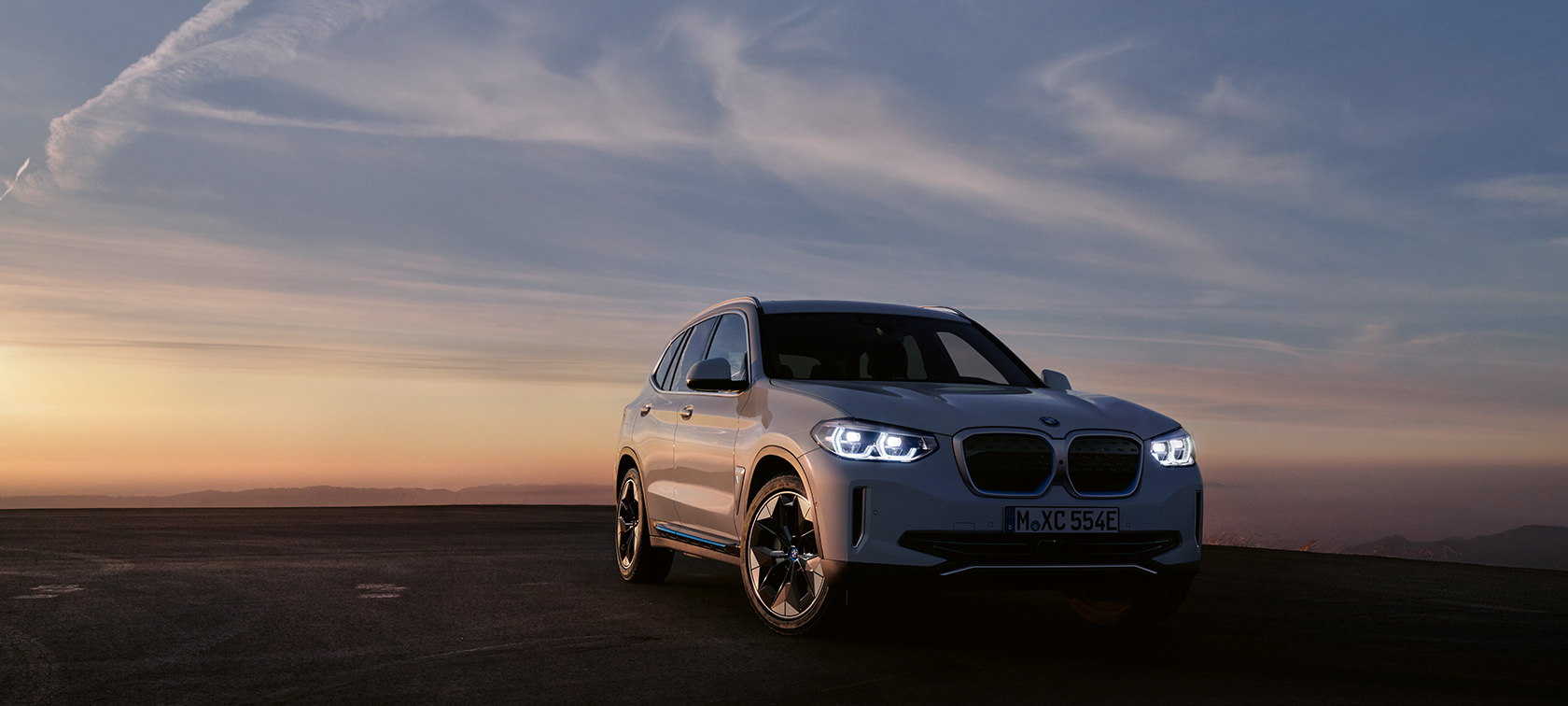 BMW iX3 G08 2020 trijų ketvirčių vaizdas iš priekio BMW iX3 G08 2020 vakaro atmosferoje stovinčio automobilio trijų ketvirčių vaizdas iš priekio