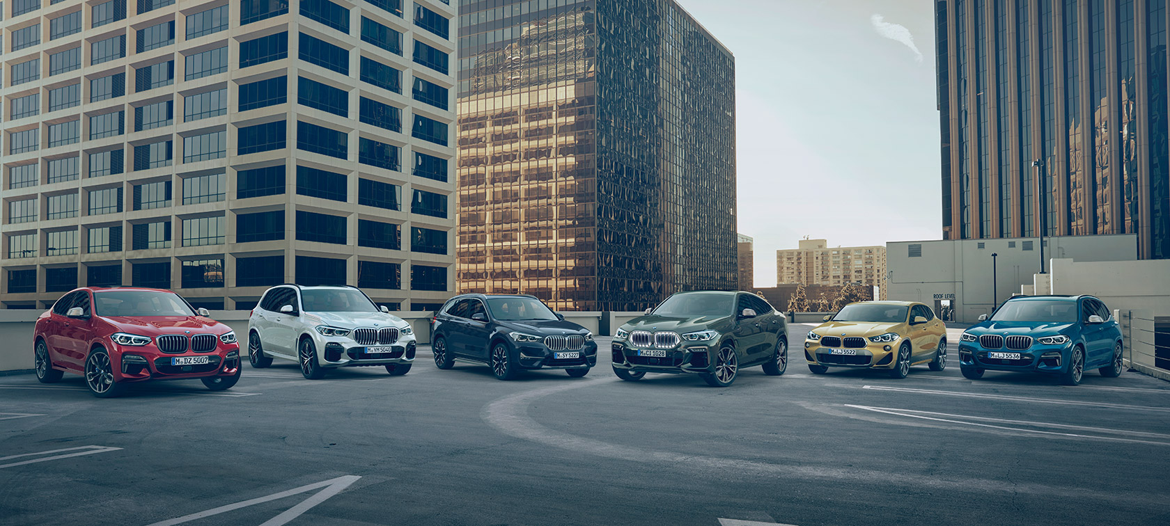 BMW X automobiliai stovėjimo aikštelėje pastatų fone BMW X serijos BMW X automobiliai stovėjimo aikštelėje pastatų fone