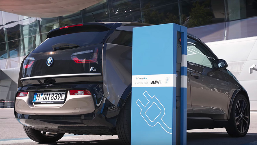 BMW i3 (i01) įkrovimo stotelėje BMW i3 (i01) trijų ketvirčių vaizdas iš galo įkrovimo stotelėje