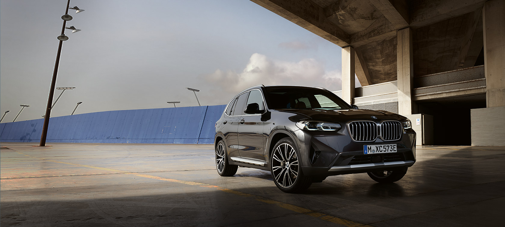 BMW X3 (G01) pilkos Sophisto Grey spalvos trijų ketvirčių vaizdas iš priekio angaro fone