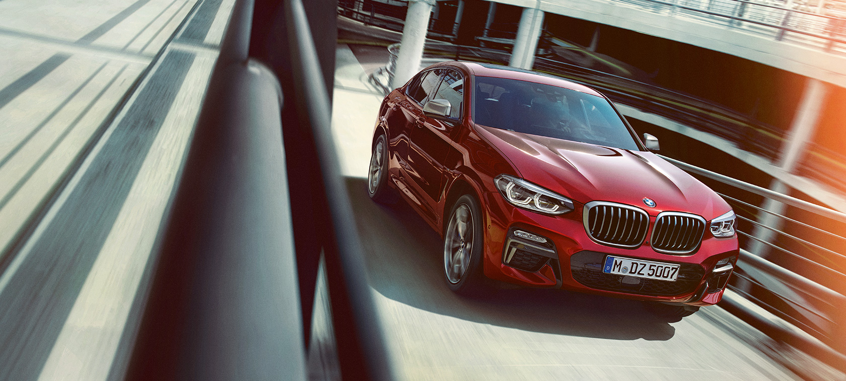 BMW X4 daugiaaukštėje stovėjimo aikštelėje BMW X4 G02 2018 Flamenco Red brilliant effect tviskančios raudonos spalvos trijų ketvirčių vaizdas iš šono daugiaaukštėje stovėjimo aikštelėje