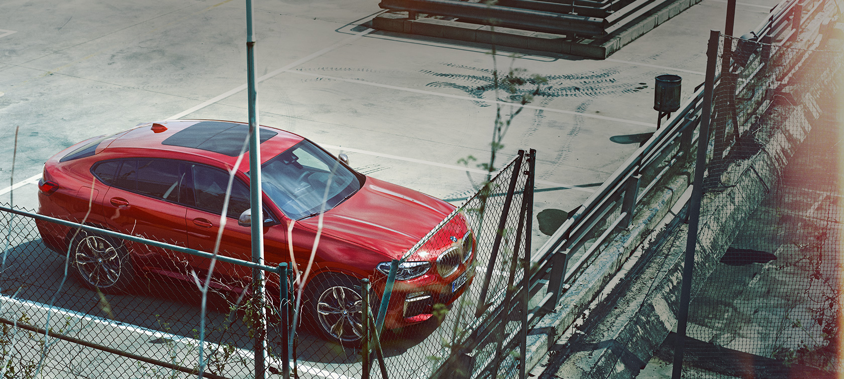 BMW X4 parkavimas BMW X4 G02 2018 Flamenco Red brilliant effect tviskančios raudonos spalvos parkuojasi aikštelėje vaizdas iš paukščio skrydžio