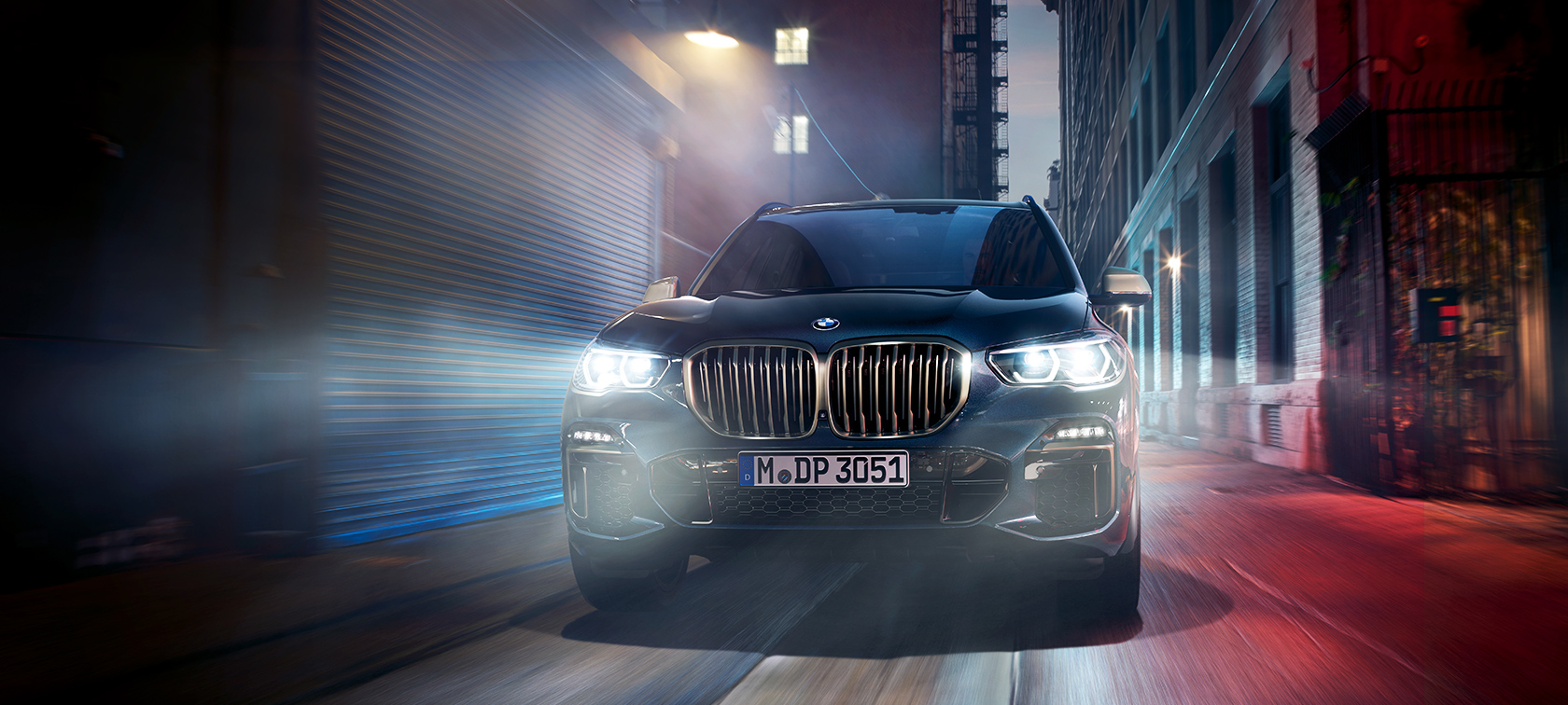 BMW X5 M50d veiksme BMW X5 M50d naktinėje miesto gatvėje