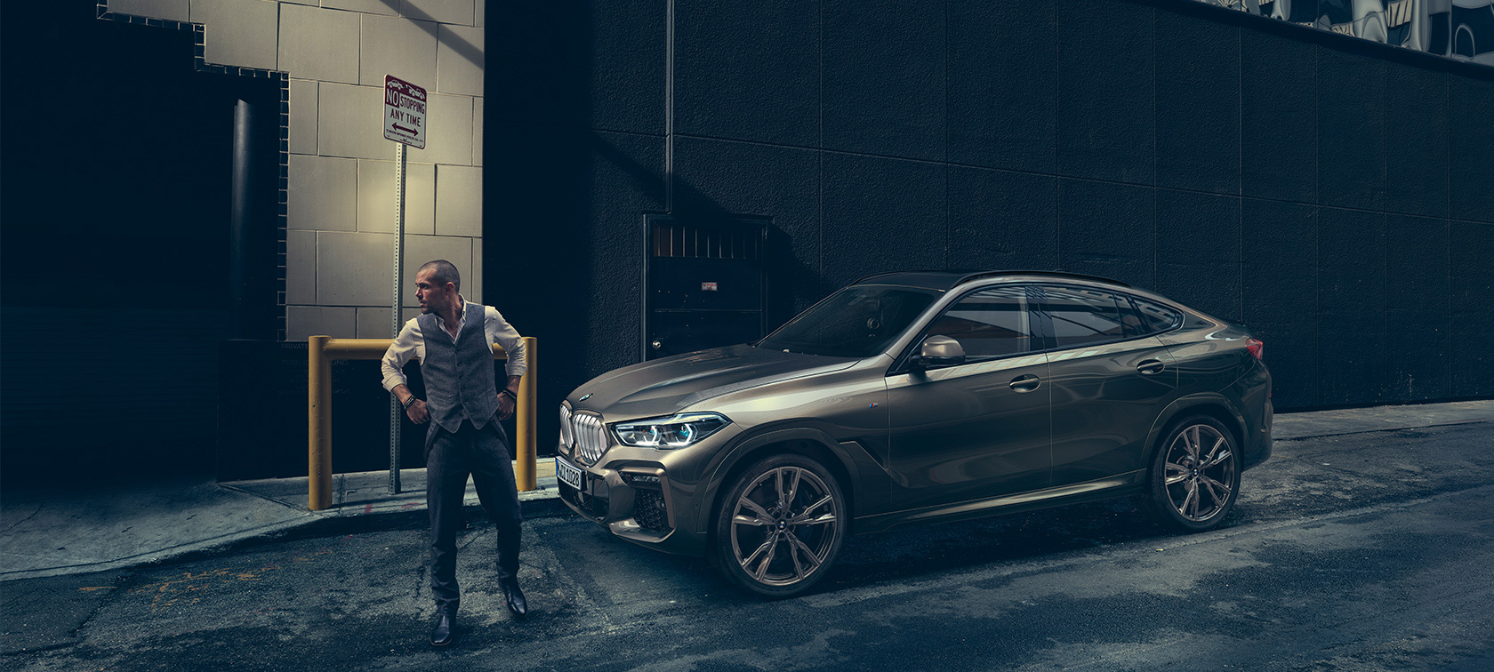 BMW X6 vaizdas iš šono miesto fone