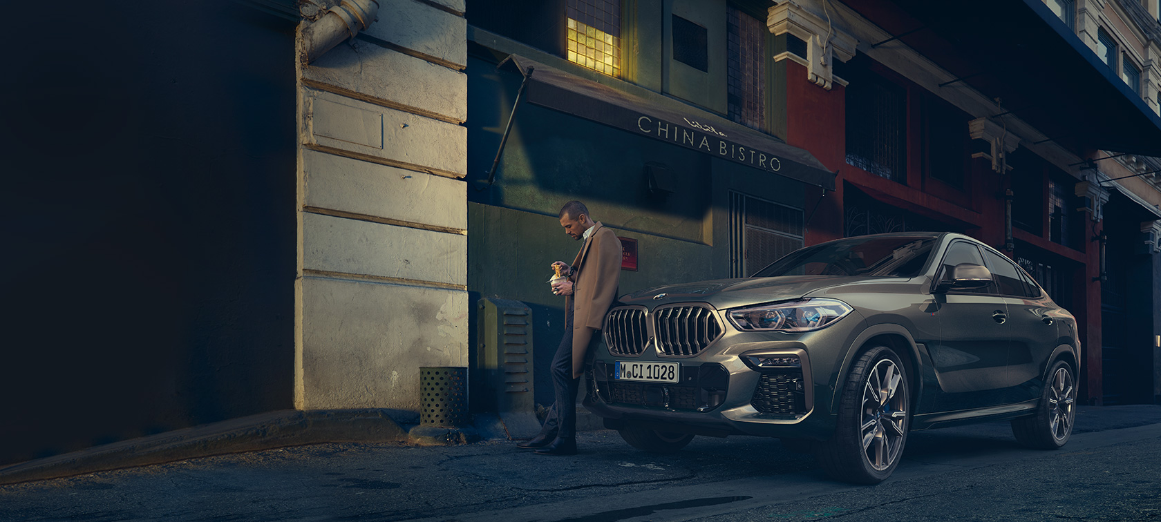 BMW X6 važiuojančio keliu automobilio trijų ketvirčių vaizdas iš galo BMW X6 (G06) 2019 metalizuotos Manhatten spalvos, važiuojančio automobilio trijų ketvirčių vaizdas iš galo