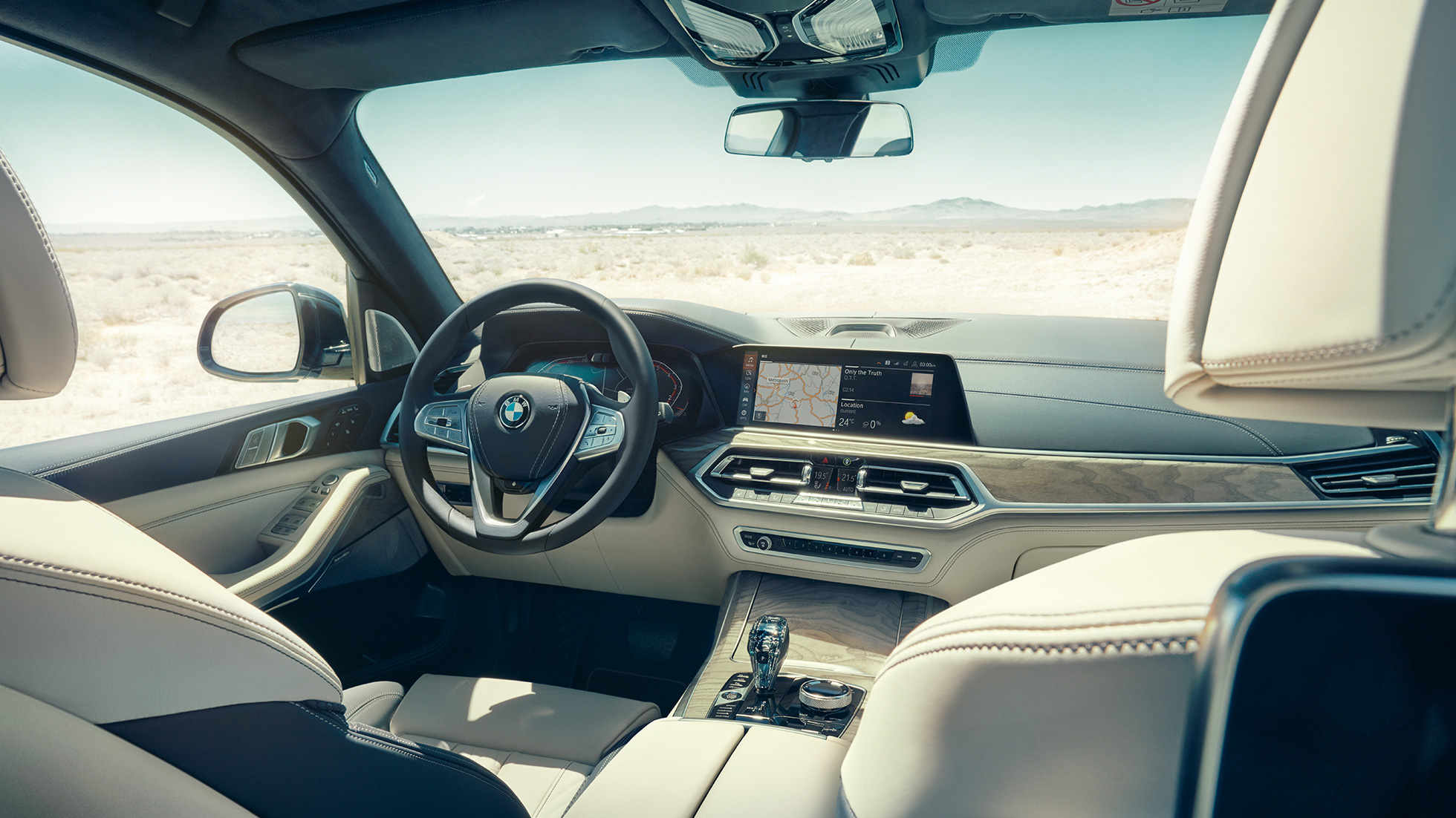 BMW Live Cockpit Professional BMW Live Cockpit Professional: Vaizdas žvelgiant iš galo į priekinę sėdynių eilę, apimant vairą ir prietaisų skydelį