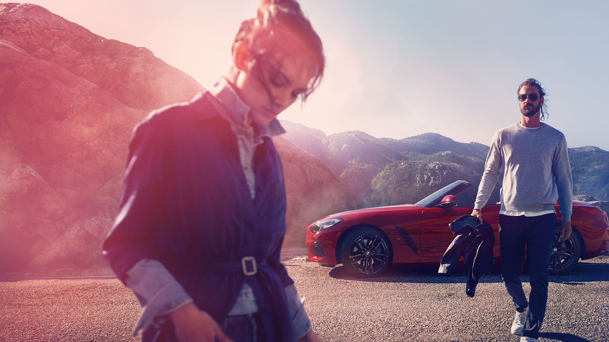 BMW Z4 Roadster vaizdas iš priekio kalnų fone Vyras, moteris ir BMW Z4 Roadster kalnų fone