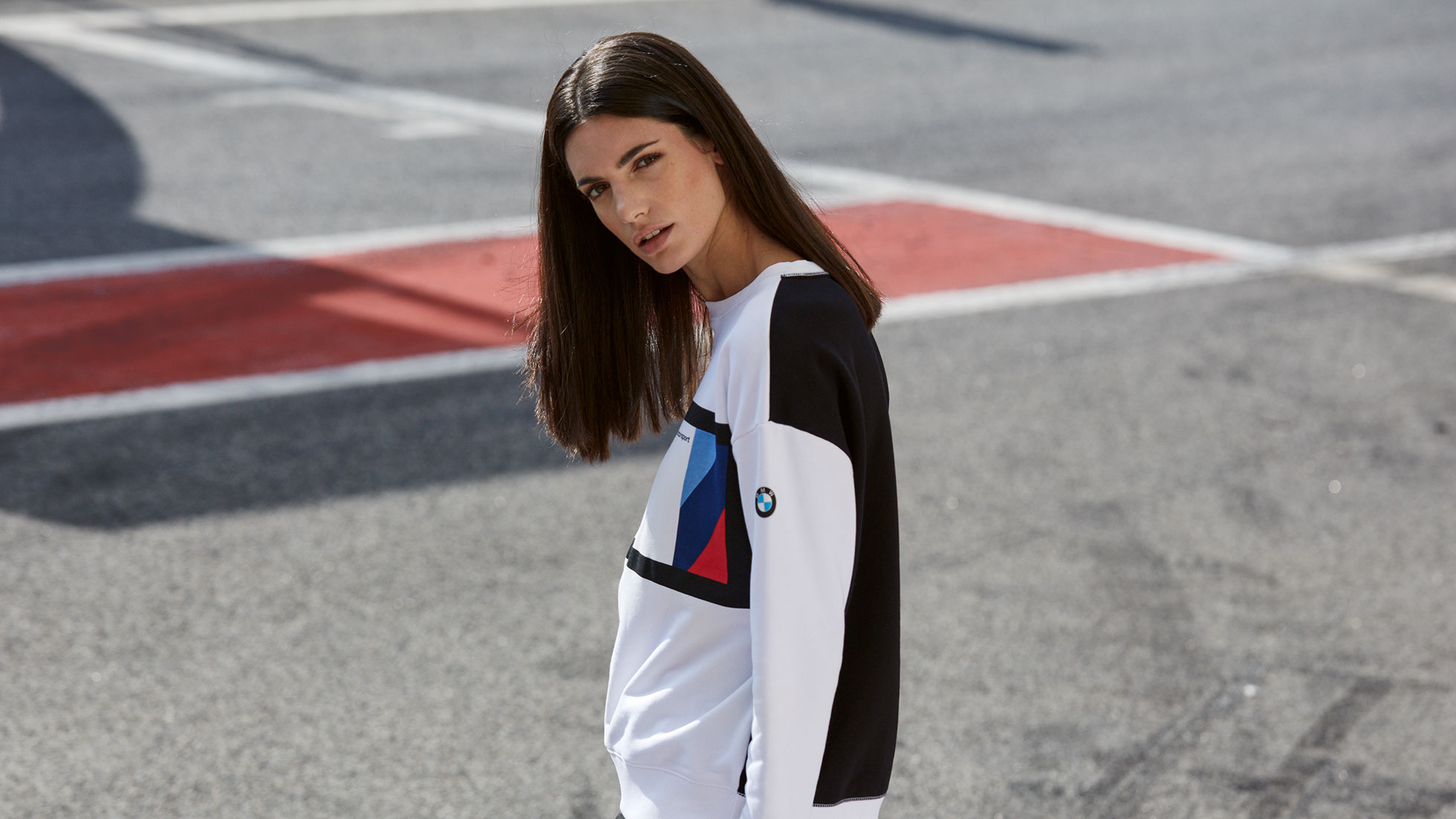 BMW M Motorsport moteriškas megztinis traukia akį, kur bebūtumėte. Nuotraukoje - mergina, vilkinti moterišką BMW M Motorsport megztinį.