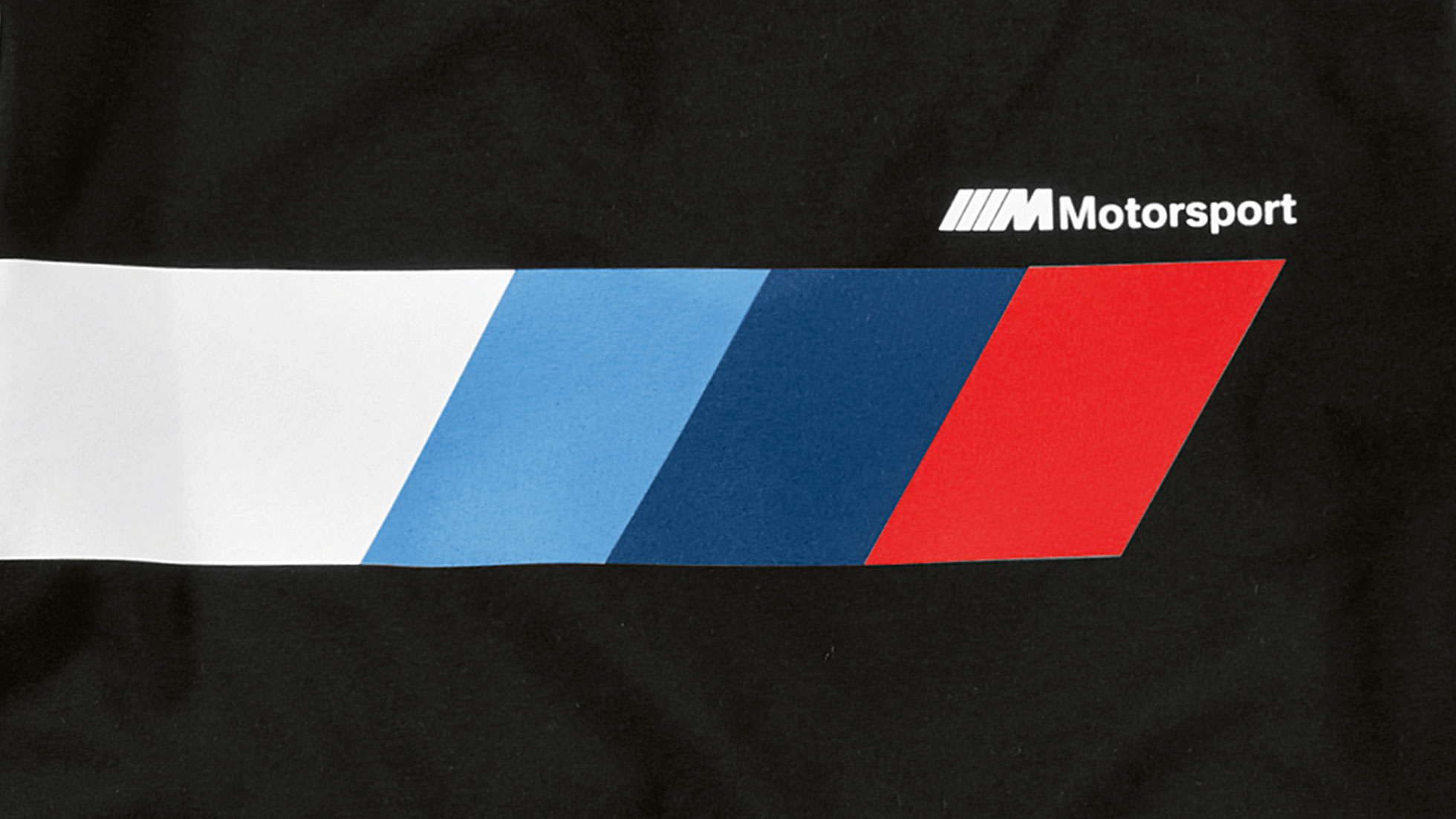 BMW M Motorsport moteriška striukė atrodo įspūdingai net išlipus iš BMW automobilio. Gaminio iliustracijoje – BMW M Motorsport kolekcijos logotipo, matomo, pavyzdžiui, ant moteriškos striukės, vaizdas iš arti.