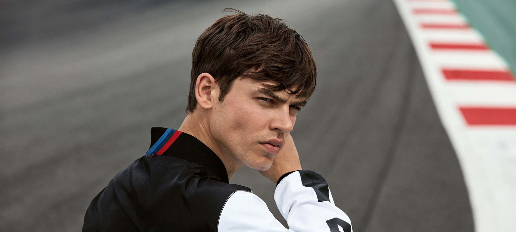 Vaikinas demonstruoja BMW M Motorsport vyrišką striukę. Vaikinas demonstruoja BMW M Motorsport vyrišką striukę.