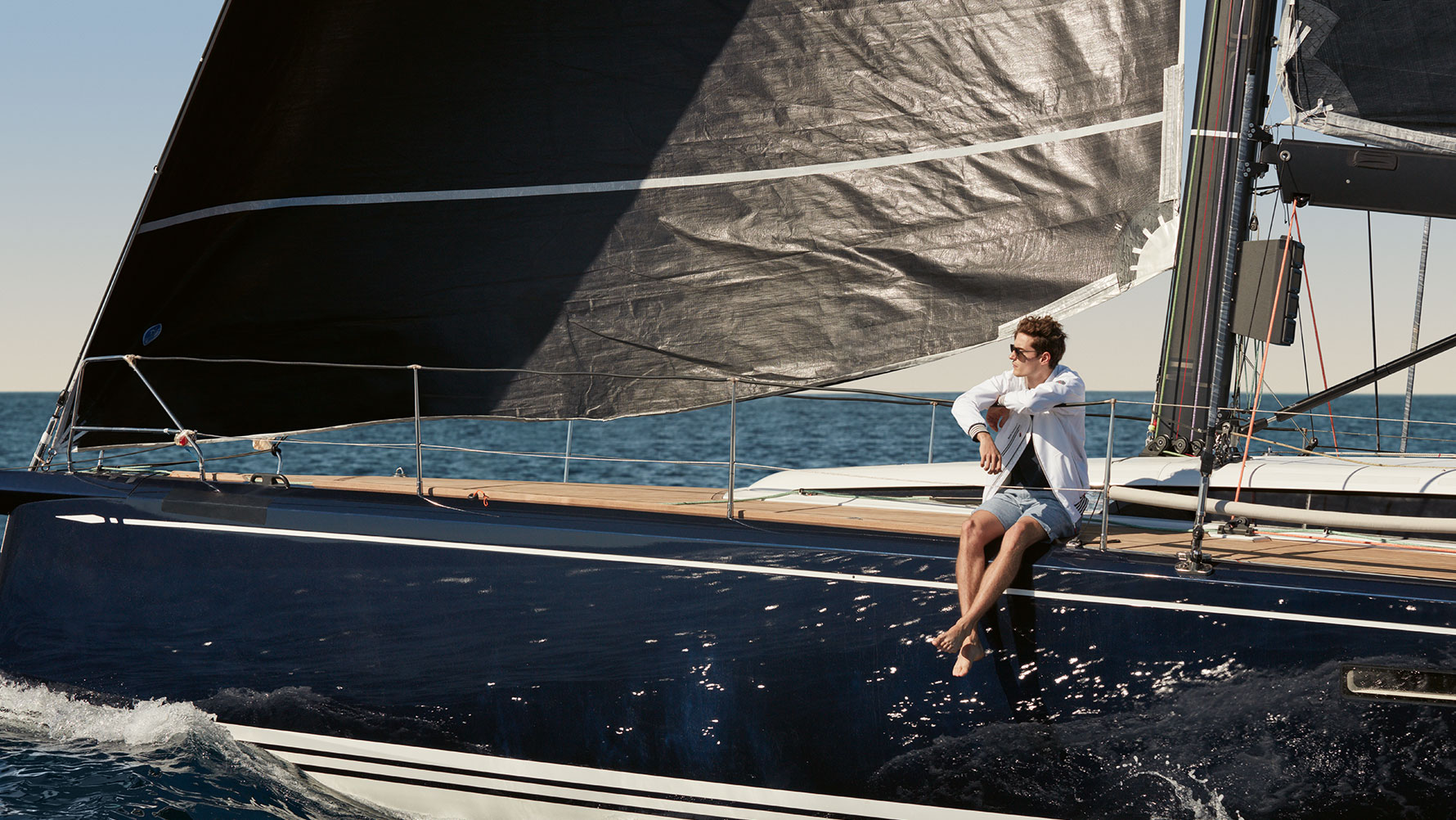 Nuotraukoje vyras, sėdintis jachtoje ir dėvintis BMW Yachtsport vyrišką striukę iš BMW Yachtsport kolekcijos. Nuotraukoje vyras, sėdintis jachtoje ir dėvintis BMW Yachtsport vyrišką striukę iš BMW Yachtsport kolekcijos.