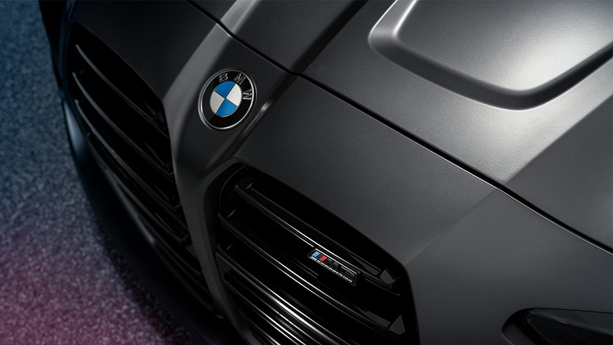 BMW M4 Competition kupė (G82) 2021 pilkos Frozen Dark Grey metalizuotos spalvos priartintas priekinis vaizdas iš viršaus BMW M4 Competition kupė (G82) 2021 pilkos Frozen Dark Grey metalizuotos spalvos priartintas priekinis vaizdas iš viršaus