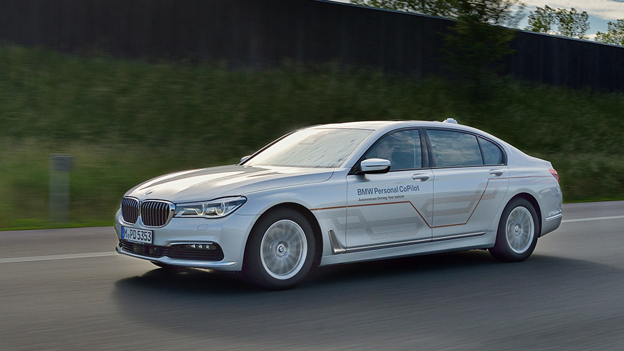 Pilkas BMW 7 serijos sedanas Pilkas BMW 7 serijos sedanas važiuoja per tiltą horizonto fone