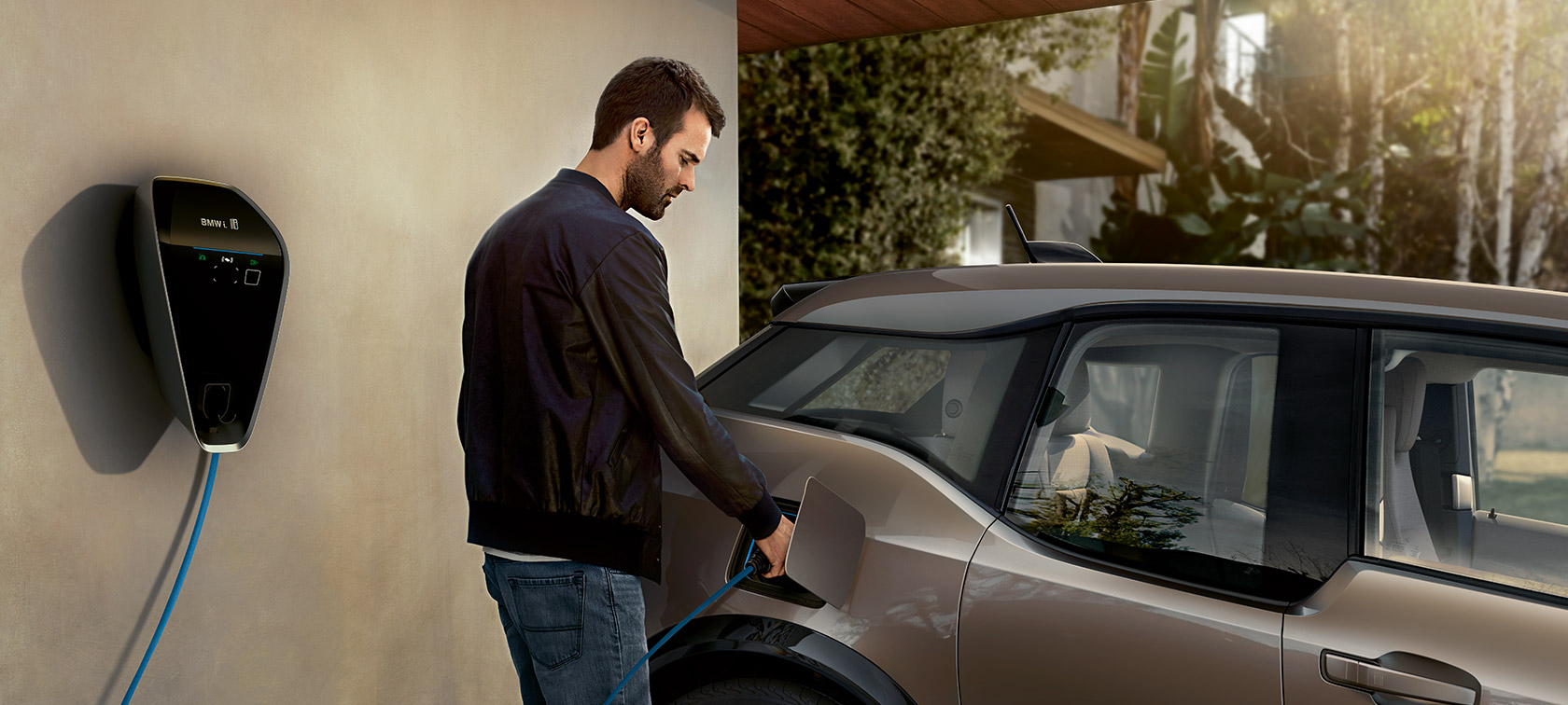 Vyras įkrauna BMW i3. Vyras įkrauna BMW i3 BMW i Wallbox stotelėje.