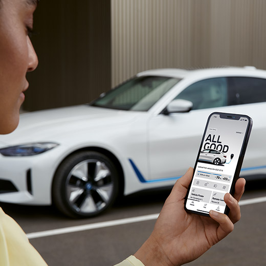 Connected Charging BMW App programėlė, šalia BMW i4 G26 stovintis žmogus pirmame plane.