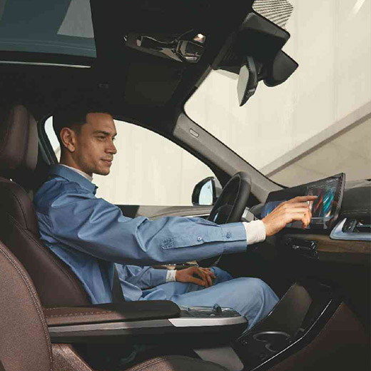 Connected Charging BMW vyras naudojasi išlenktu BMW ekranu