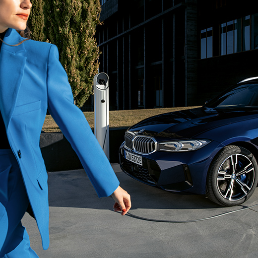 Įkrovimo situacija su BMW fone einančia moterimi