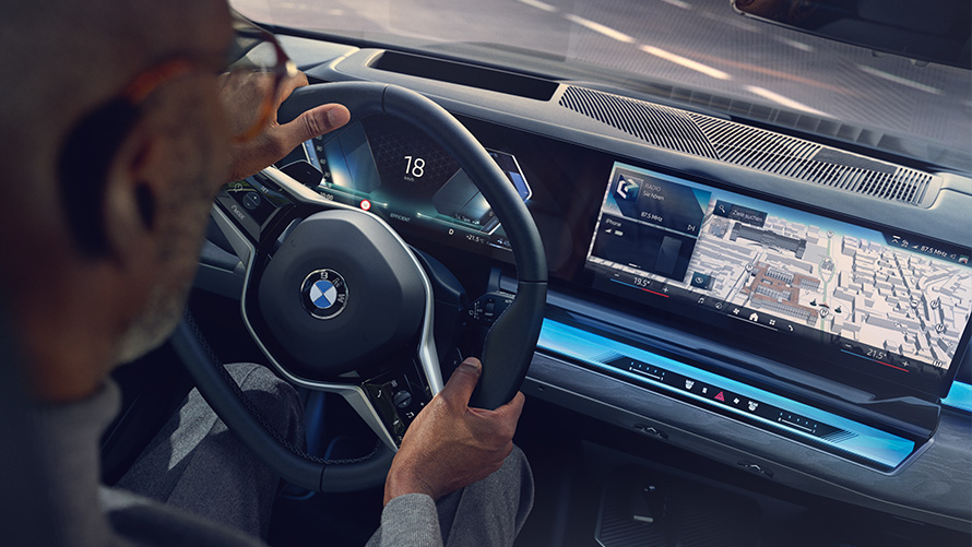 BMW interjeras į ekraną su operacine sistema 8.5 žiūrintis vyras BMW interjeras į ekraną su operacine sistema 8.5 ir žemėlapiais žiūrintis vyras