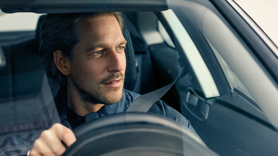 BMW vairuojantis vyras BMW vairuojantis vyras žvelgia pro priekinį stiklą