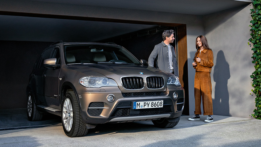 Priešais garažą su modeliais stovintis BMW automobilis BMW Value Service paslaugos, priešais garažą su modeliais stovintis BMW automobilis