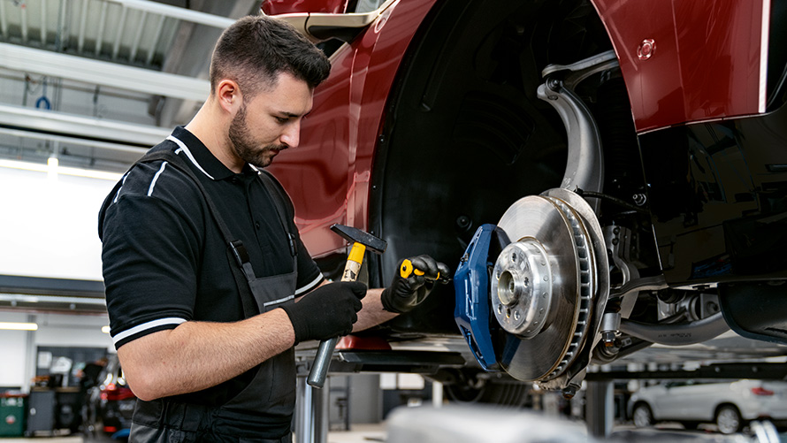 BMW Service Inclusive Plus pasiūlymai BMW Service Inclusive Plus serviso darbuotojas remontuoja stabdžius